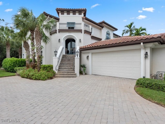 28520 Calabria Ct Unit 201, Naples, FL 34110 - mediterranean / spanish home with a balcony, a tiled roof, decorative driveway, stucco siding, and french doors