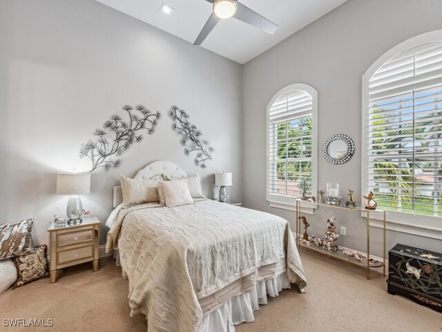 carpeted bedroom featuring lofted ceiling and ceiling fan