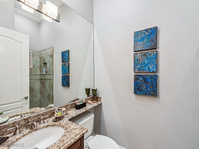 bathroom with vanity, tiled shower, and toilet