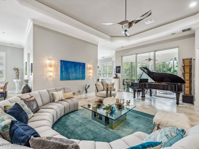 tiled living room with crown molding, a raised ceiling, and ceiling fan