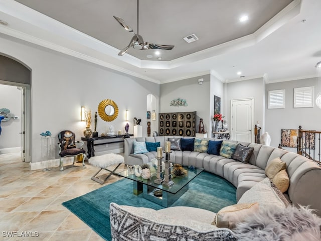 living room with ornamental molding and a tray ceiling