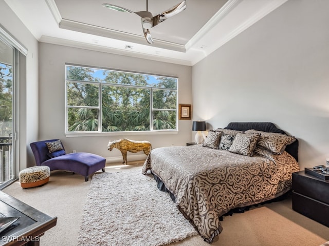 carpeted bedroom with ceiling fan, a raised ceiling, and crown molding