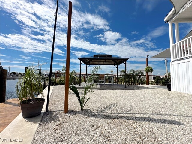 exterior space featuring a gazebo, a water view, and a patio area