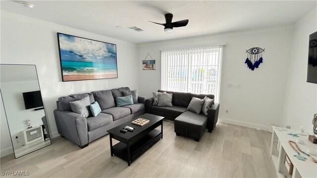 living room with light hardwood / wood-style floors, crown molding, a textured ceiling, and ceiling fan