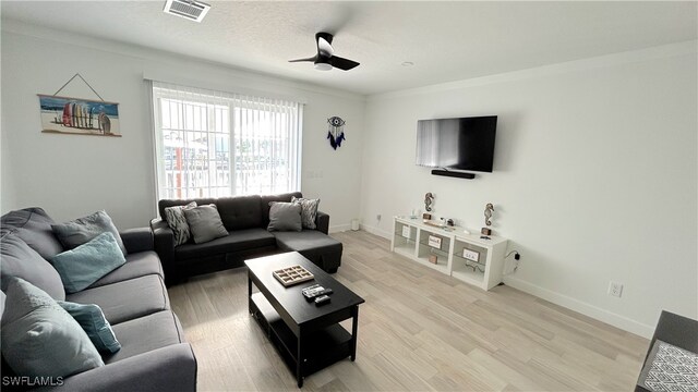 living room featuring crown molding, light wood-type flooring, and ceiling fan