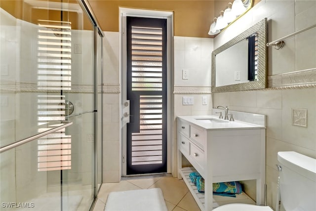 bathroom featuring toilet, an enclosed shower, tile patterned floors, and tile walls