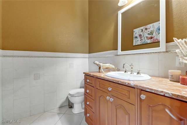 bathroom featuring toilet, vanity, tile walls, and tile patterned flooring