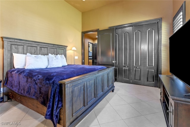 bedroom with a high ceiling and light tile patterned floors