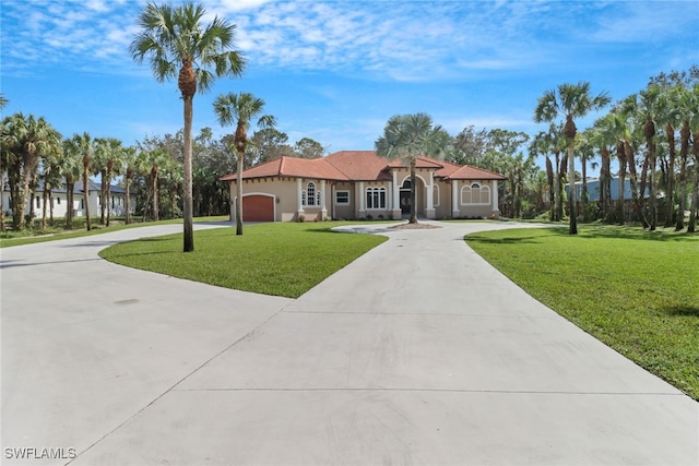 mediterranean / spanish home with a front yard and a garage