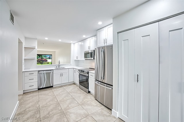 kitchen featuring appliances with stainless steel finishes, light tile patterned flooring, sink, and white cabinets