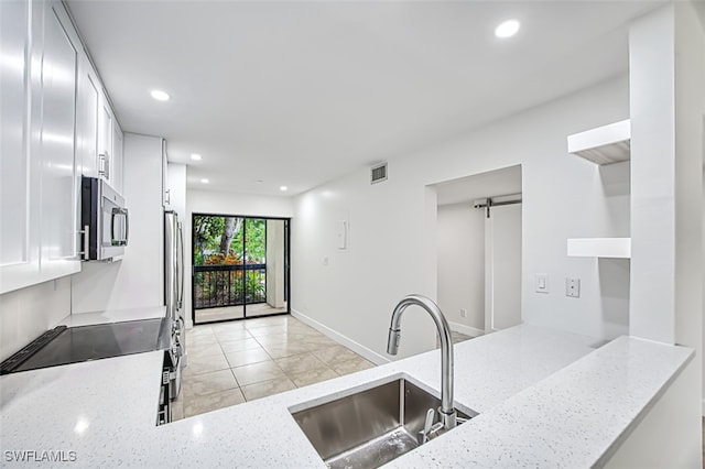 kitchen featuring light stone countertops, sink, stainless steel appliances, and white cabinets