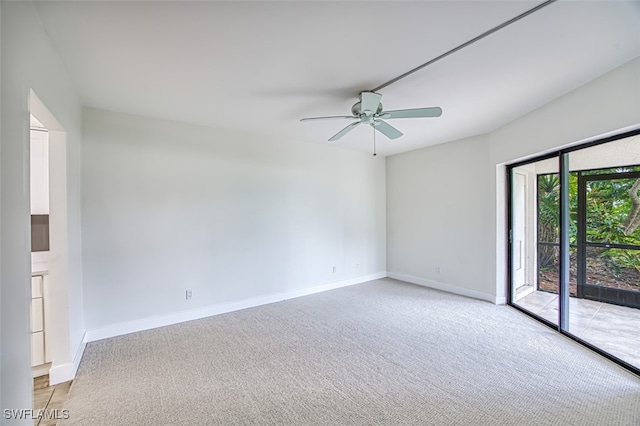 carpeted spare room featuring ceiling fan