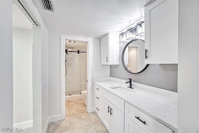 bathroom featuring tile patterned floors, an enclosed shower, vanity, and toilet