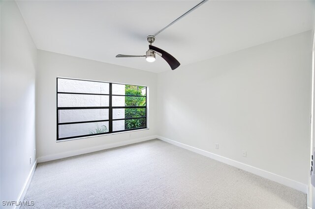 carpeted spare room featuring ceiling fan