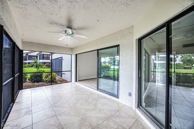 unfurnished sunroom with ceiling fan