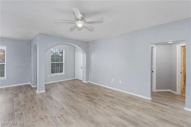 unfurnished room featuring ceiling fan, a wealth of natural light, and light hardwood / wood-style flooring