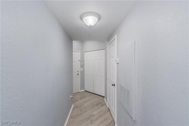 hallway with light hardwood / wood-style floors