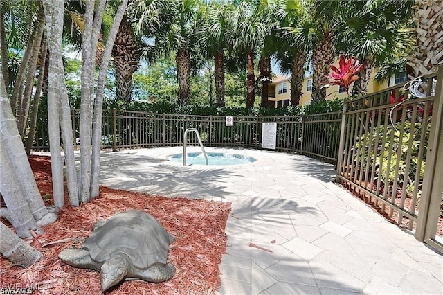 view of swimming pool featuring a patio and a hot tub