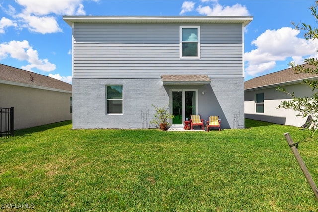 back of property featuring a patio and a lawn