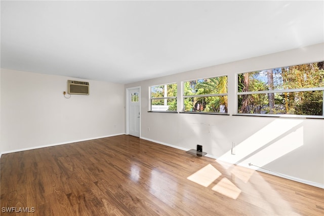 1235 Rordon Ave, Naples, FL 34103 - empty room featuring a wall mounted AC, wood finished floors, and baseboards