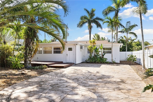 view of front of house with a wooden deck and a patio