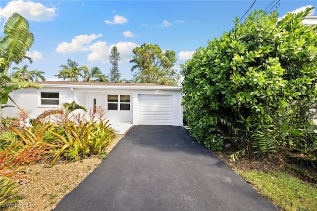 1235 Rordon Ave, Naples, FL 34103 - view of front facade with an attached garage, asphalt driveway, and stucco siding