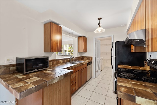 kitchen featuring stainless steel appliances, extractor fan, pendant lighting, sink, and tile counters