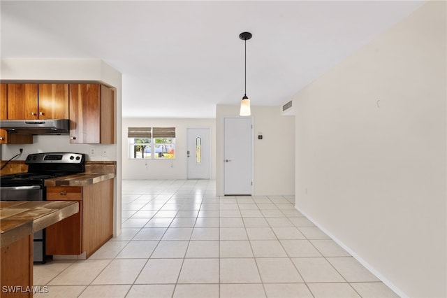 kitchen featuring hanging light fixtures, light tile patterned floors, and stainless steel electric stove