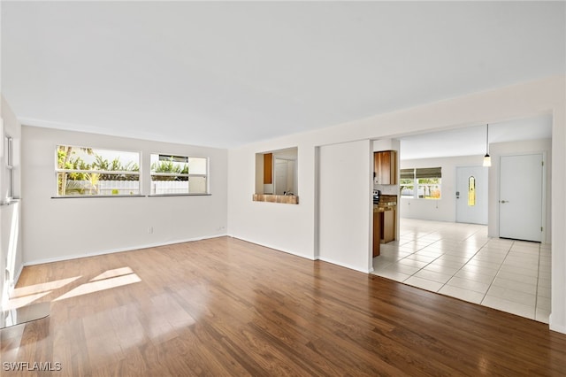 empty room with a wealth of natural light and light hardwood / wood-style flooring