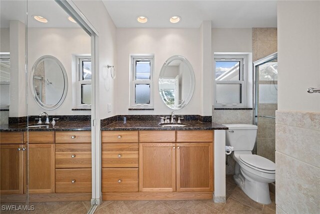 bathroom with tile patterned floors, vanity, toilet, and tile walls