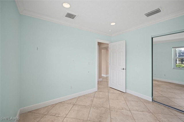 unfurnished bedroom featuring ornamental molding and light tile patterned flooring