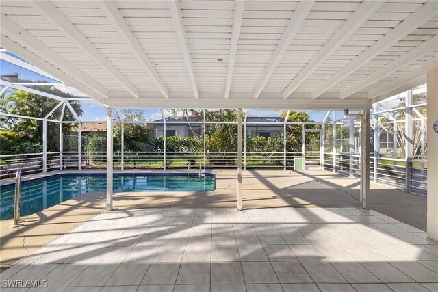 view of swimming pool with glass enclosure and a patio