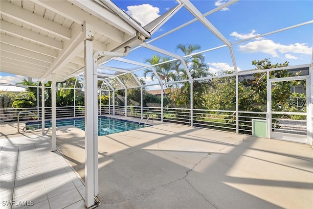 view of pool with glass enclosure and a patio