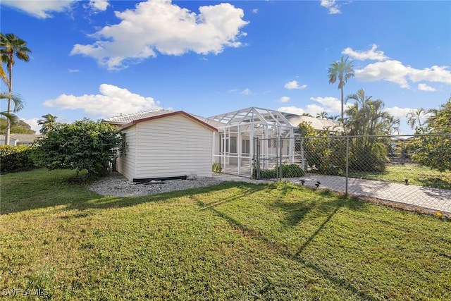 back of house with a lanai and a yard