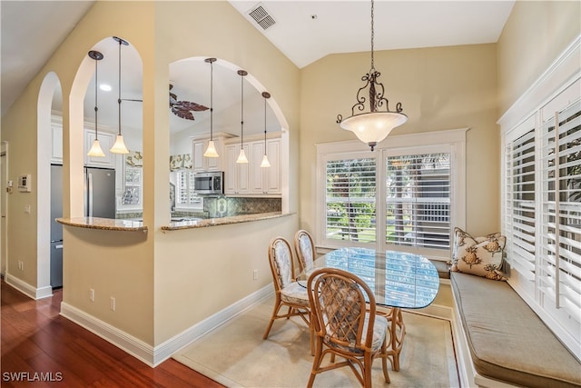 dining area featuring lofted ceiling and dark hardwood / wood-style flooring