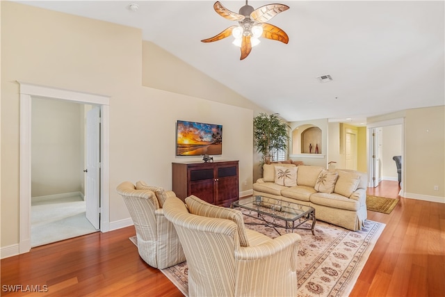 living room with hardwood / wood-style flooring, ceiling fan, and vaulted ceiling