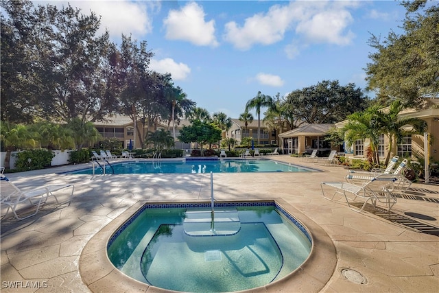 view of pool featuring a hot tub and a patio area