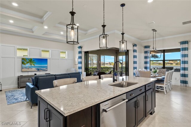 kitchen with beam ceiling, hanging light fixtures, coffered ceiling, stainless steel dishwasher, and a kitchen island with sink