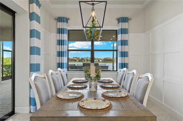 dining area featuring crown molding, a chandelier, and a decorative wall