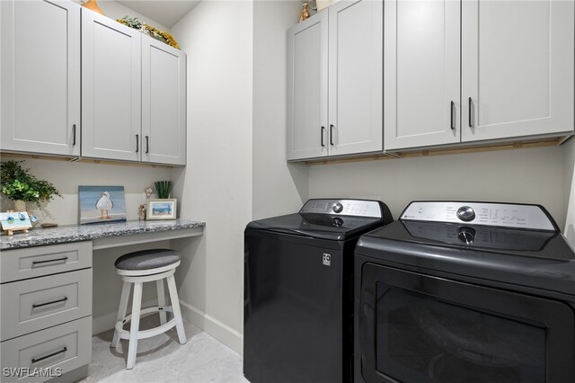 clothes washing area with cabinets and washer and clothes dryer