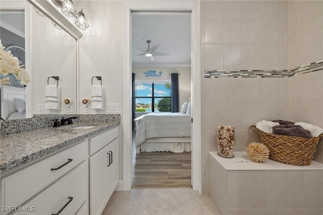 bathroom featuring vanity, ceiling fan, ornamental molding, and tile walls