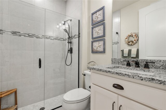 bathroom with vanity, an enclosed shower, and toilet