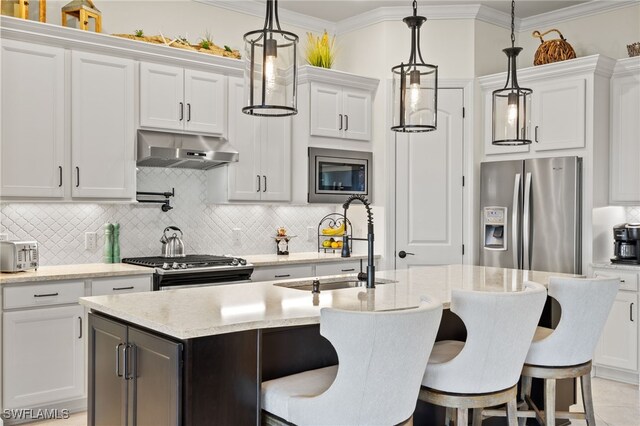 kitchen with white cabinets, backsplash, stainless steel appliances, and hanging light fixtures