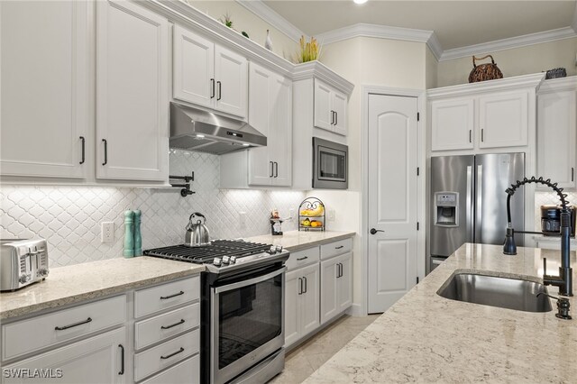 kitchen with backsplash, white cabinets, crown molding, sink, and appliances with stainless steel finishes