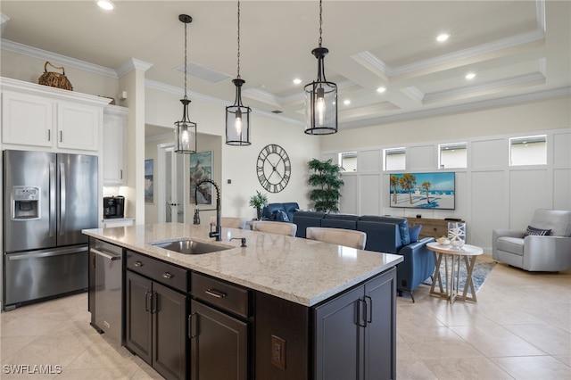 kitchen featuring white cabinetry, sink, decorative light fixtures, a kitchen island with sink, and appliances with stainless steel finishes