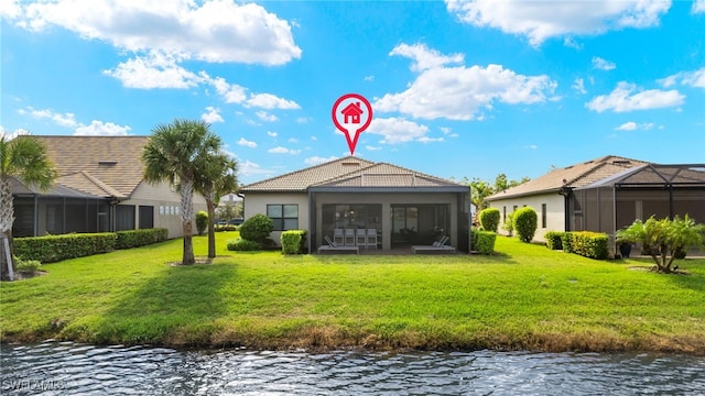 rear view of property with a sunroom, a water view, a lanai, and a lawn