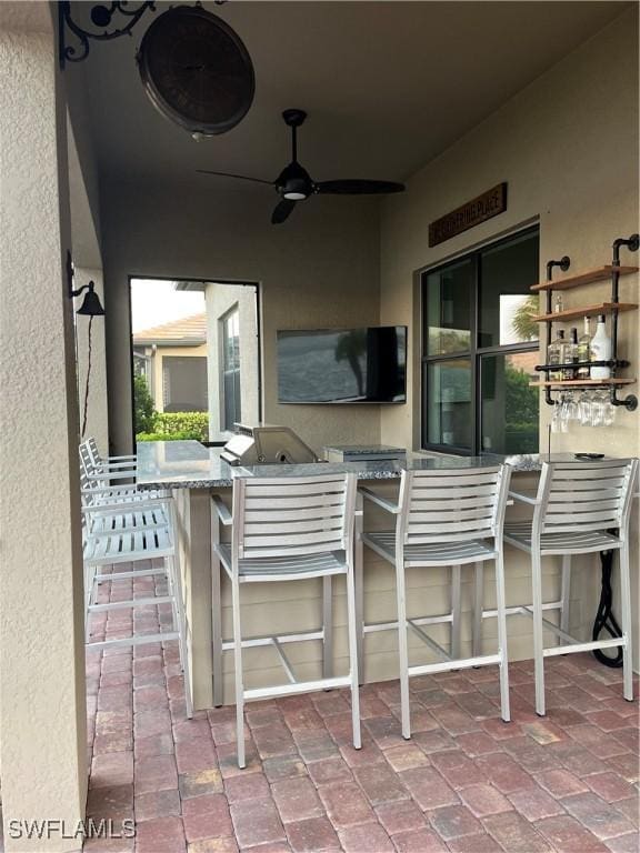 view of patio / terrace featuring ceiling fan and a bar