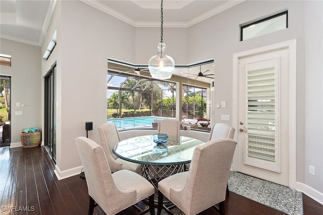 dining space with crown molding, a towering ceiling, and dark hardwood / wood-style flooring