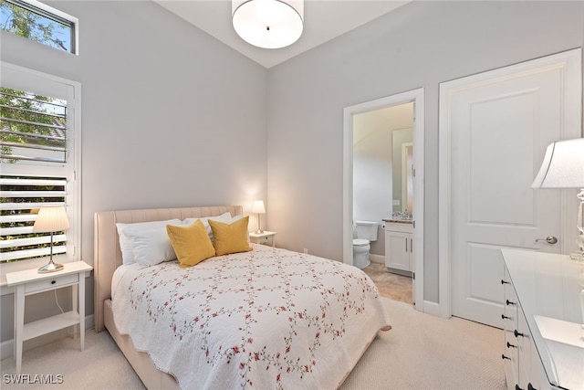 bedroom featuring light carpet and ensuite bathroom