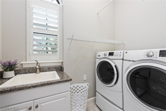 washroom featuring independent washer and dryer, light tile patterned flooring, cabinets, and sink